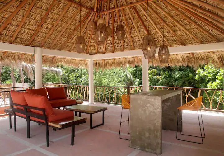 The rooftop palapa with lounge chairs and a bar